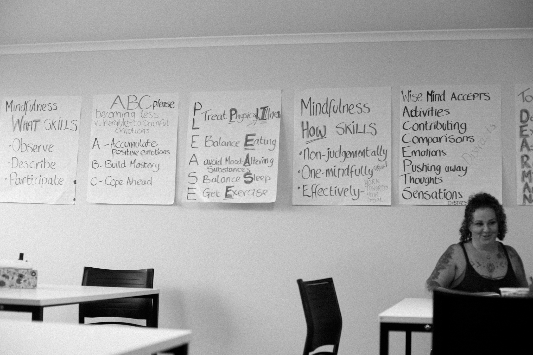 DBT skills worksheets covering the wall of a Life Mental Health group room