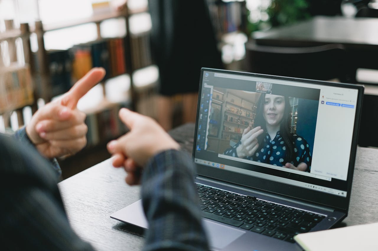 Person engaging in a telehealth therapy session on a laptop